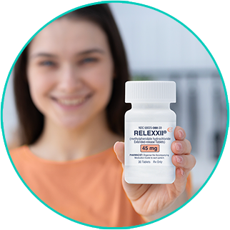 Smiling woman holding a bottle of RELEXXII (methylphenidate HCl ER) tablets from her pharmacy